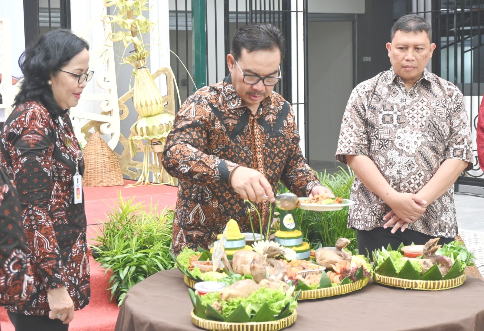 Wali Kota Yogyakarta, Hasto Wardoyo (tengah) ketika "nyidhug" tumpeng pada acara tradisi "Wiwitan" Pembukaan Awal Pasar Terban, Gondokusuman Yogyakarta, didampingi Kepala Dinas Perdagangan Kota Yogyakarta dan Ketua Paguyuban Pedagang Unggas Pasar Terban Yogyakarta, Selasa (30/12/2025). Foto: dialoguejakarta.com/ Ist